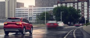 A red 2020 Ford Escape driving on a highway in the rain in San Antonio, TX