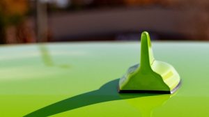 A custom antenna on a green car parked in San Antonio, TX