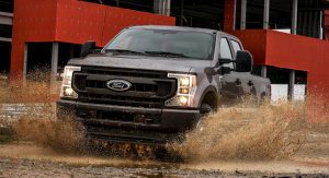 A black 2021 Ford F-250 Super Duty driving through some mud on a worksite in San Antonio, TX