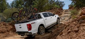 A white 2022 Ford Ranger Lariat driving on an off-road trail near San Antonio, TX
